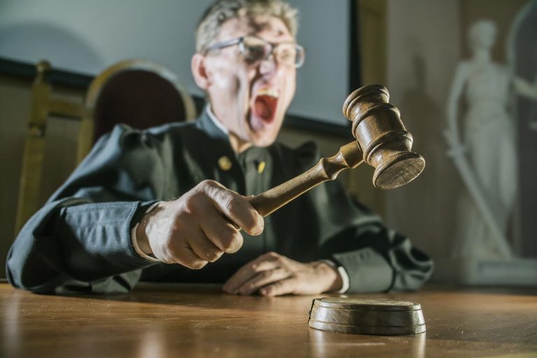 angry man a judge with a hammer in his hand in the court room HRWatchdog